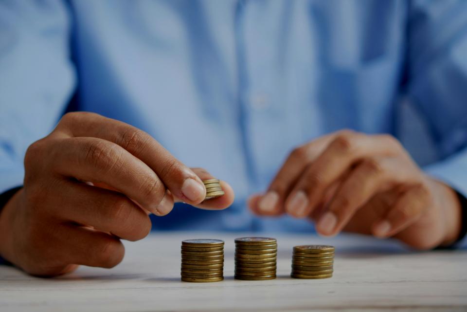persona apilando monedas